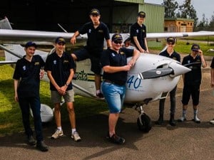 Group of Scouts posing in front of a plane